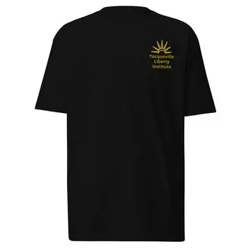 Black heavyweight t-shirt with a small gold Tocqueville Liberty Institute sunburst emblem on the chest